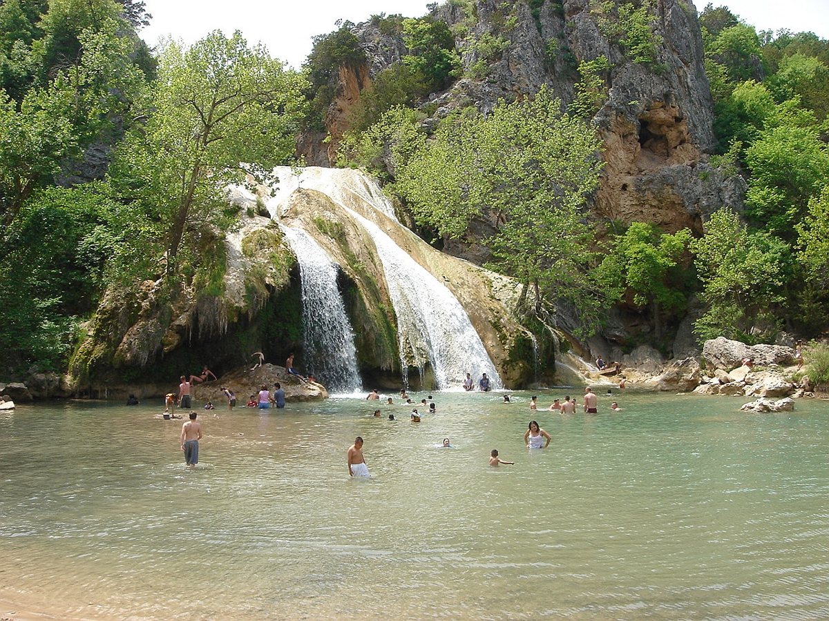 Turner Falls waterfall flowing into a clear swimming hole in the Arbuckle Mountains of southern Oklahoma