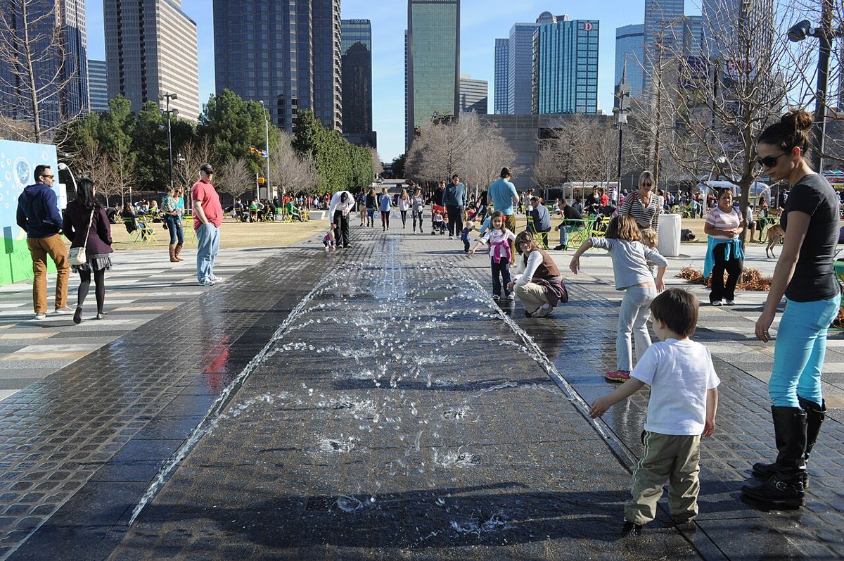 families and food trucks on the great lawn at Klyde Warren Park with the Dallas skyline in the background