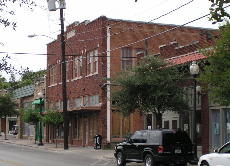 Pedestrians walking past independent shops and restaurants on the brick streets of Bishop Arts District Dallas