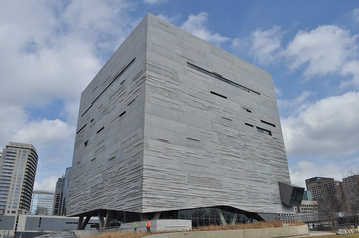 Modern stone and glass exterior of the Perot Museum of Nature and Science in Dallas Victory Park